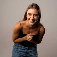 Thumbnail for Smiling woman in casual outfit radiating joy and happiness against a neutral background.