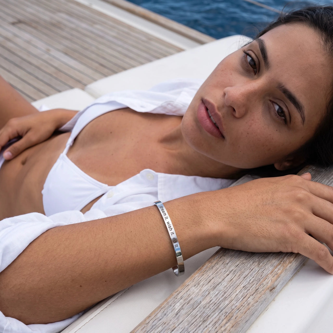 Woman on a yacht wearing the silver engraved cuff bracelet | SKU: 4214557-silver-plated