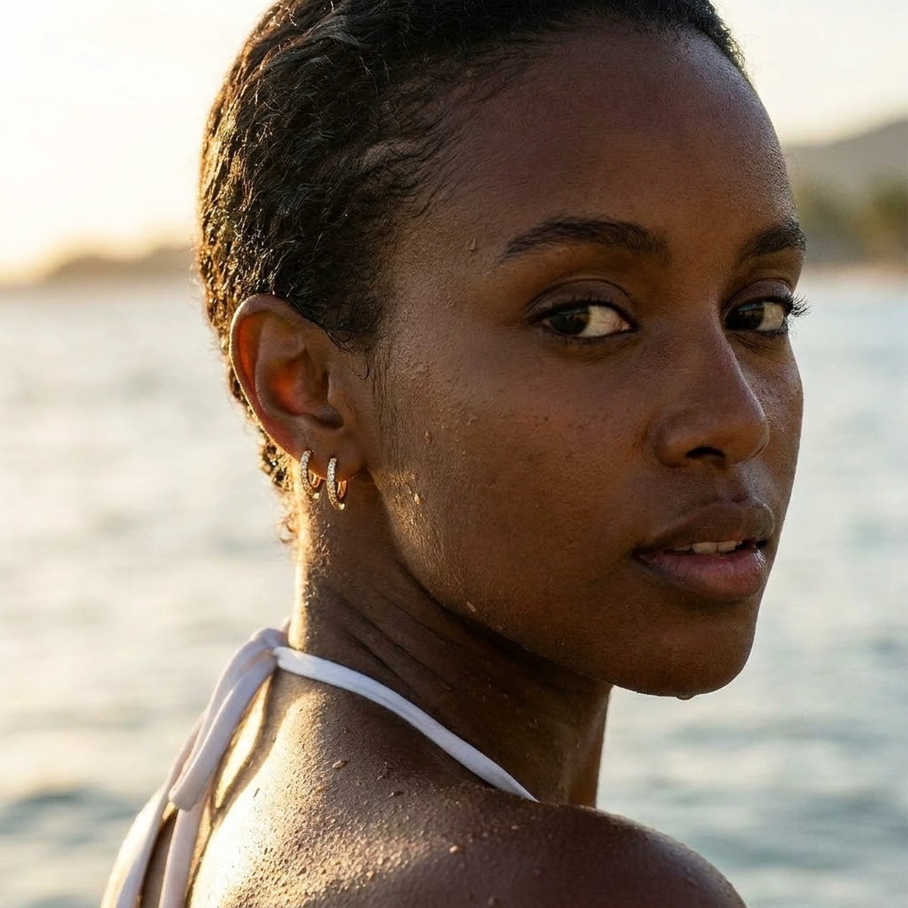 Pave Huggie Hoop Earrings in Gold, worn in the sea, wet skin | SKU: 41011-gold