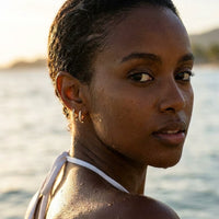 Thumbnail for Pave Huggie Hoop Earrings in Gold, worn in the sea, wet skin | SKU: 41011-gold