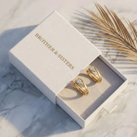 Thumbnail for Pear Crystal Huggie Hoops in Gold, in the gift box | SKU: 41007-gold