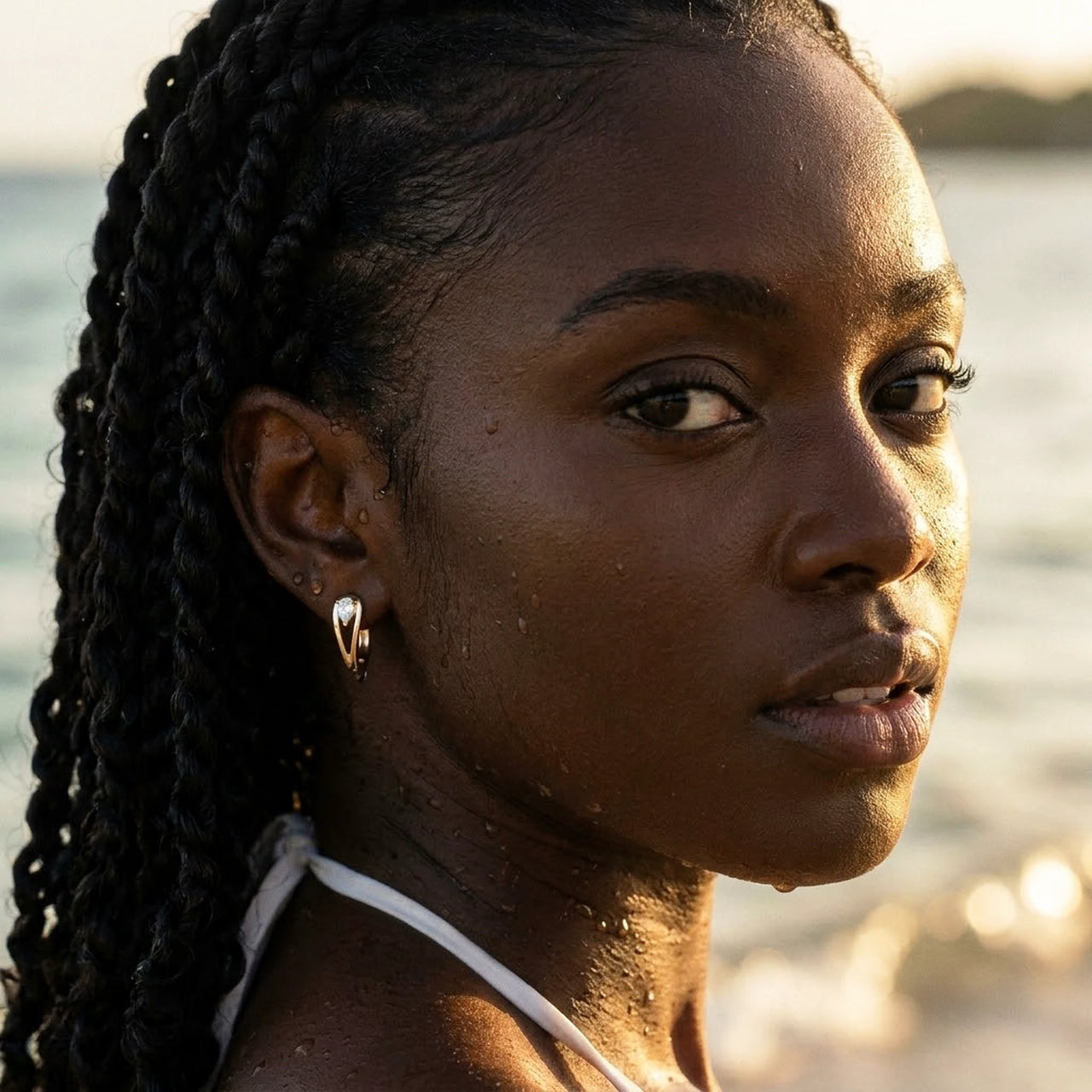 Pear Crystal Huggie Hoops in Gold, worn in the sea, wet skin | SKU: 41007-gold