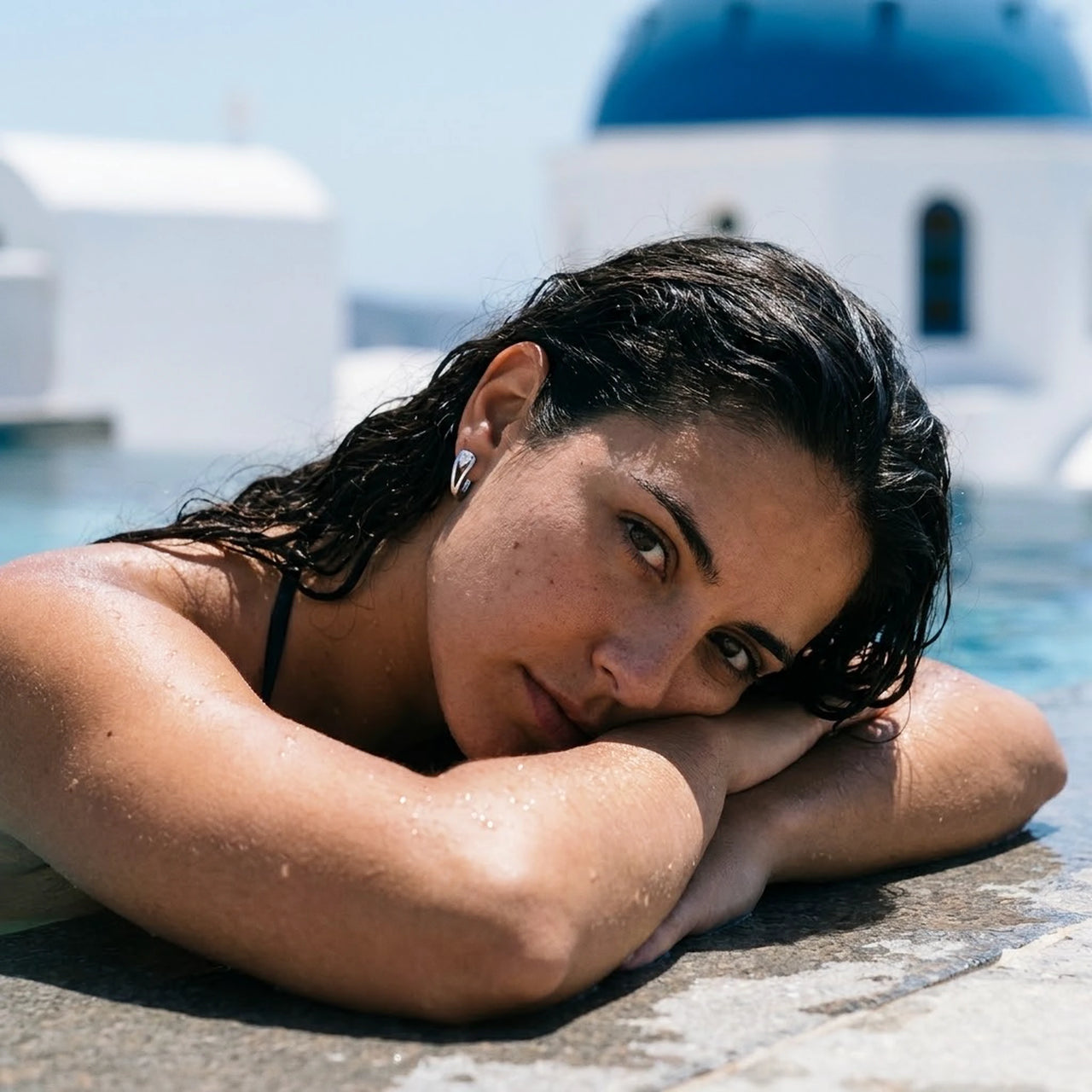 Pear Crystal Huggie Hoops in Silver, worn by a pool in Santorini | SKU: 41007-silver