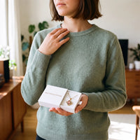 Thumbnail for Woman in a green sweater holding the Brother & Sisters gift box with the gold clover photo necklace inside | SKU: TPH-CLVN-GOLD