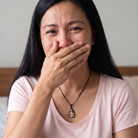 Thumbnail for Woman covering her mouth, moved to tears, wearing the black secret drop photo necklace | SKU: TPH-DRPN-BLACK