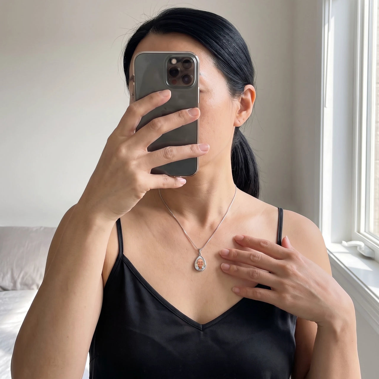 Mirror selfie of a woman in a black camisole wearing the silver secret drop photo necklace | SKU: TPH-DRPN-SILVER