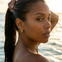 Thumbnail for Tiny Huggie Hoops in Gold, worn in the sea, wet skin | SKU: 41002-gold