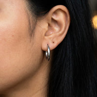 Thumbnail for Tiny Huggie Hoops in Silver, close-up on the earlobe | SKU: 41002-silver