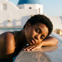 Thumbnail for Twisted Pearl Drop Hoops in Gold, worn by a pool in Santorini | SKU: 41004-gold