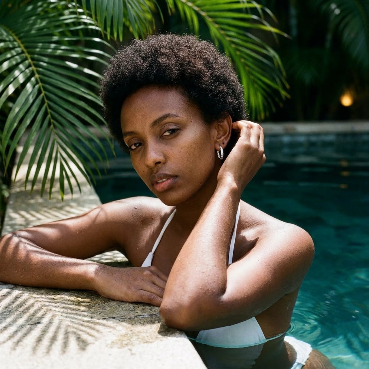 Twisted Rope Huggie Hoops in Silver, worn by a tropical pool | SKU: 41012-silver